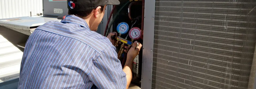 HVAC technician servicing a condenser unit in Seneca