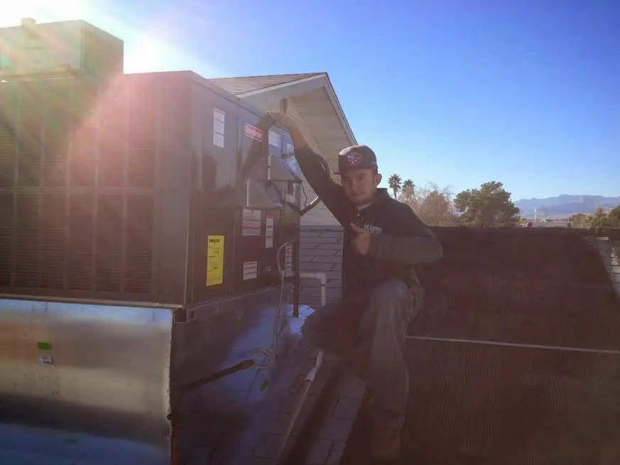 HVAC technician performing Heat Pump Repair on a rooftop unit in Seneca